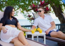 couple lounging chairs with drinks by the pool