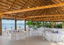 an outdoor tiki set up for a group dining event overlooking the ocean