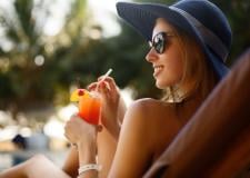 A beautiful woman in a sunhat sipping a refreshing cocktail