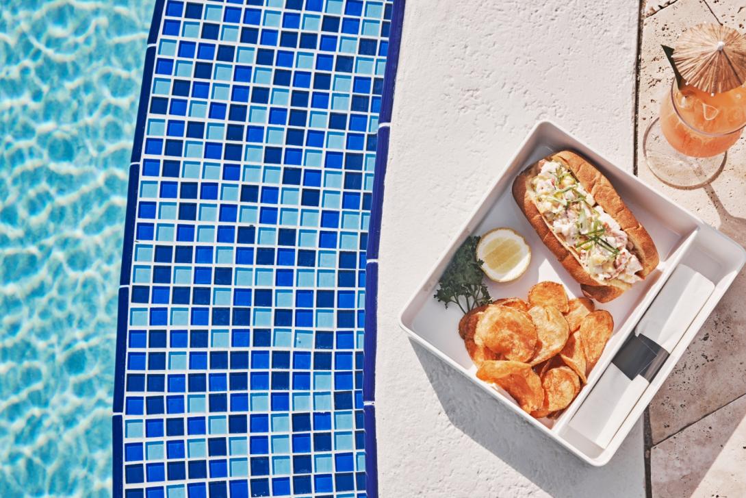 A plate of food sitting by the pool.